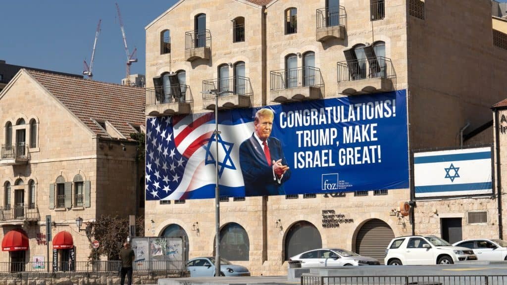 Thank you Banner with the photo of the President of the United States and the combination of the flags of Israel and the United States. The banner is in an old building.