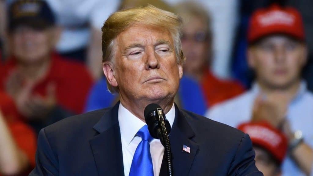 Donald Trump looking down from behind a microphone